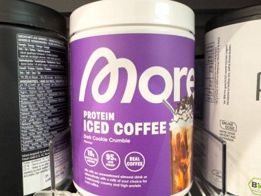 Villach, Austria - October 09, 2025: More Protein Iced Coffee in Dark Cookie Crumble flavor is prominently displayed on a shelf, highlighting its appealing design and delicious look