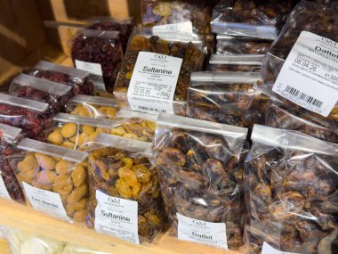 Villach, Austria - October 09, 2025: Assorted dried fruits in clear bags on wooden shelves at market, highlighting healthy snack choices and vibrant colors