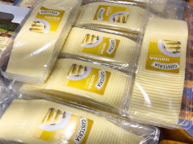 Villach, Austria - October 09, 2025: Packaged slices of Gustaria Gouda cheese in clear plastic, highlighting the rich yellow color and brand details