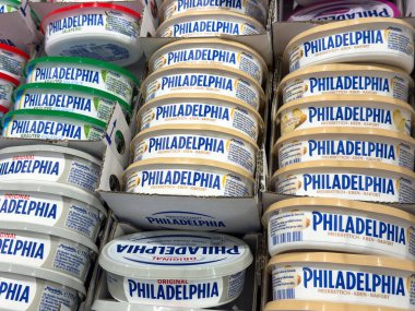 Villach, Austria - October 09, 2025: Philadelphia cream cheese varieties displayed on grocery store shelf, highlighting different flavors and appealing packaging