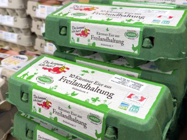 Villach, Austria - October 09, 2025: Green cartons of organic free-range eggs are neatly stacked in a grocery store, highlighting eco-friendly packaging and branding