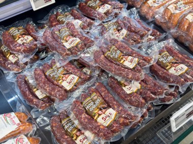Villach, Austria - October 09, 2025: Display of house-made sausage packages in grocery store, featuring rich textures and vibrant colors, perfect for food photography