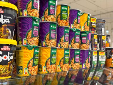 Villach, Austria - October 09, 2025: Vibrant Knorr noodle cans are neatly arranged in a grocery store, highlighting diverse flavors and appealing packaging