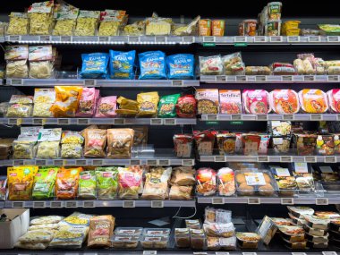 Villach, Austria - October 09, 2025: Vibrant assortment of packaged food items arranged on supermarket shelves, highlighting diverse snacks and meal options available for shoppers