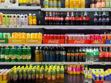 Villach, Austria - October 09, 2025: Beverage shelf displays a variety of soft drinks, juices, and water bottles in a supermarket with vibrant colors and packaging