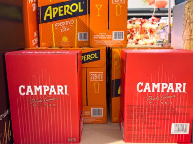 Villach, Austria - October 09, 2025: Campari and Aperol boxes are prominently displayed together, highlighting popular Italian aperitifs in a colorful retail environment