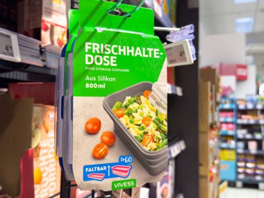 Villach, Austria - October 09, 2025: Food storage container packaging is prominently displayed in supermarket, featuring colorful design and fresh vegetables