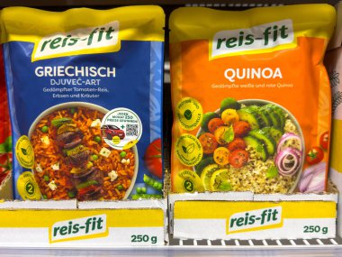 Villach, Austria - October 09, 2025: Reis-Fit food packages include Greek-style rice and quinoa, arranged on a supermarket shelf with bright colors and attractive graphics
