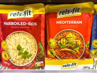 Villach, Austria - October 09, 2025: Reis-fit rice packages feature parboiled and Mediterranean varieties, displayed on a supermarket shelf with bright colors and enticing designs