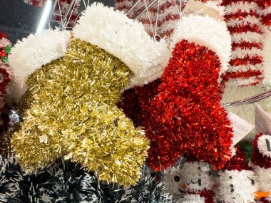 Villach, Austria - October 09, 2025: Decorative Christmas stockings in gold and red tinsel, embodying festive spirit with vibrant colors and textures for holiday celebrations