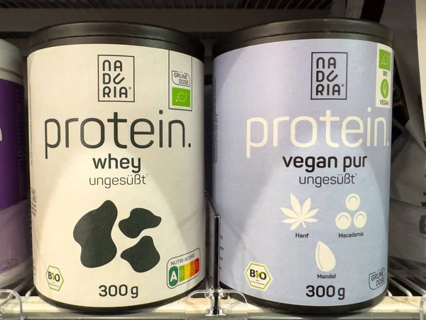 Villach, Austria - October 09, 2025: Protein powder packaging displayed in store, featuring whey and vegan varieties, promoting fitness and health-conscious diets