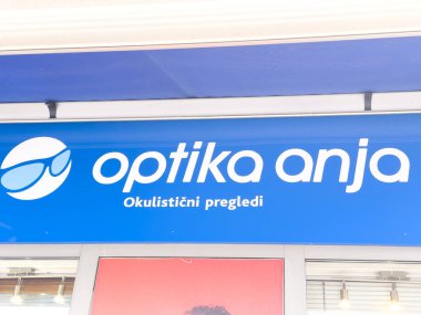 Ljubljana, Slovenia - October 10, 2025: Optika Anja sign showcases eye care services with a blue background and glasses logo, enhancing urban aesthetics