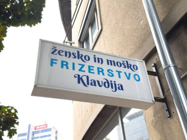 Ljubljana, Slovenia - October 10, 2025: Sign for hair salon Klavdija offers services for women and men, located in an urban area with modern architecture