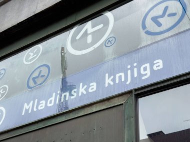 Ljubljana, Slovenia - October 10, 2025: Mladinska knjiga bookstore features a stylish window display with modern logos and reflections of the cityscape