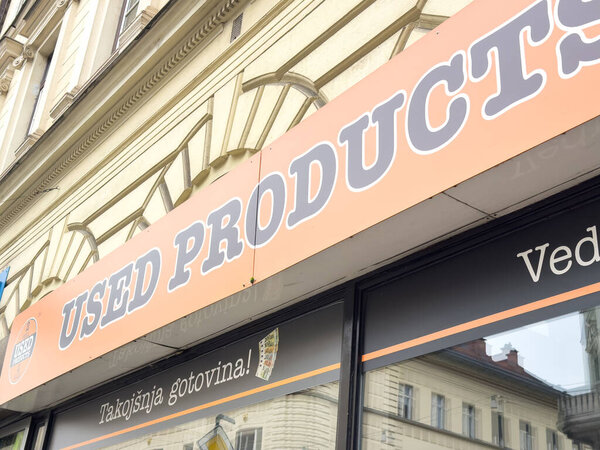 Ljubljana, Slovenia - October 10, 2025: Storefront sign for used products, promoting second-hand shopping in a vibrant urban environment with inviting colors