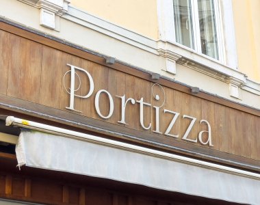 Trieste, İtalya - 14 Ekim 2025: Portizza Restoran tabelası ahşap arka planda şık harfler içeriyor, müşteriler için sıcak ve davetkar bir ortam yaratıyor