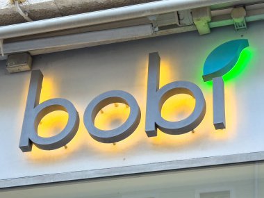 Trieste, İtalya - 14 Ekim 2025: Bobi logosu dükkan tabelasında sergilendi, parlak yeşil yaprak, sürdürülebilirlik ve modern markalaşmayı vurguluyor
