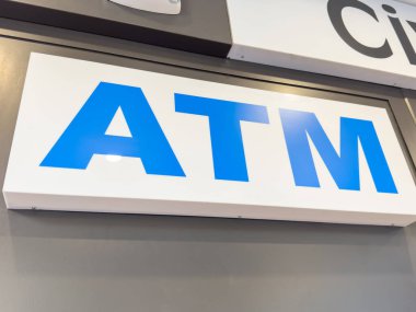 Trieste, İtalya - 14 Ekim 2025: ATM işareti tarafsız bir duvarda, kullanıcılar için para çekme hizmetinin açık bir göstergesi olan koyu mavi harfler sergiliyor