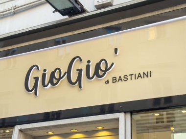 Trieste, İtalya - 14 Ekim 2025: GioGio di Bastiani mağaza vitrininde canlı bir şehir ortamında, yoldan geçenleri ürünlerini keşfetmeye çeken şık bir tabela yer alıyor.
