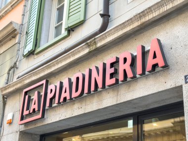 Trieste, İtalya - 14 Ekim 2025: La Piadineria yeşil panjurlu bina tabelası, canlı bir şehir atmosferindeki İtalyan yemek deneyimini vurguluyor