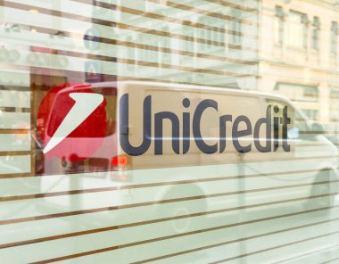 Trieste, İtalya - 14 Ekim 2025: Cam pencere üzerindeki UniCredit logosu, çağdaş bankacılık ve kentsel yaşam atmosferini gösteren şehir sokaklarını yansıtıyor