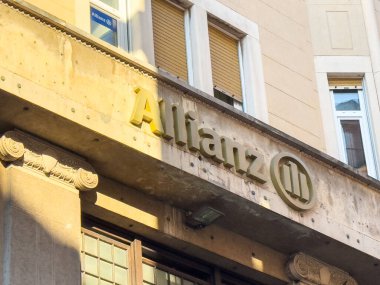 Trieste, İtalya - 14 Ekim 2025: Tarihi bina cephesinde Allianz tabelası, mimari özellikleri ve kentsel atmosferi vurgulayarak görsel cazibeyi artıran güneş ışığı