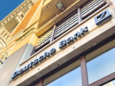 Trieste, İtalya - 14 Ekim 2025: Deutsche Bank cephesi, finans kurumunu temsil eden parlak mavi gökyüzüne karşı çağdaş tasarım ve markalaşmayı ön plana çıkardı