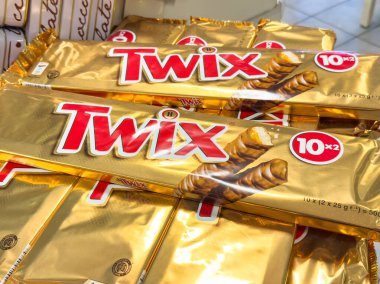 Trieste, İtalya - 14 Ekim 2025: Parlak altın ambalajlı Twix çikolataları sergilenmekte, şeker sevenler ve abur cuburculara hitap etmektedir