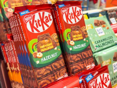 Trieste, İtalya - 14 Ekim 2025: KitKat fındık çikolataları renkli ambalajlar ve çekici tasarımlar içeren raflarda cazip bir şekilde düzenlenmiştir