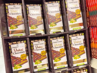 Trieste, İtalya - 14 Ekim 2025: Dubai Çikolata Kutuları, çikolata meraklıları için renkli ambalajlar ve gurme markaların yer aldığı bir rafta sergilenmektedir
