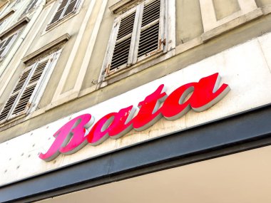 Trieste, İtalya - 14 Ekim 2025: Bata mağaza önü tabelası, klasik mimarisi ve canlı kırmızı rengini vurgulayan tarihi bir binada sergilenmektedir.