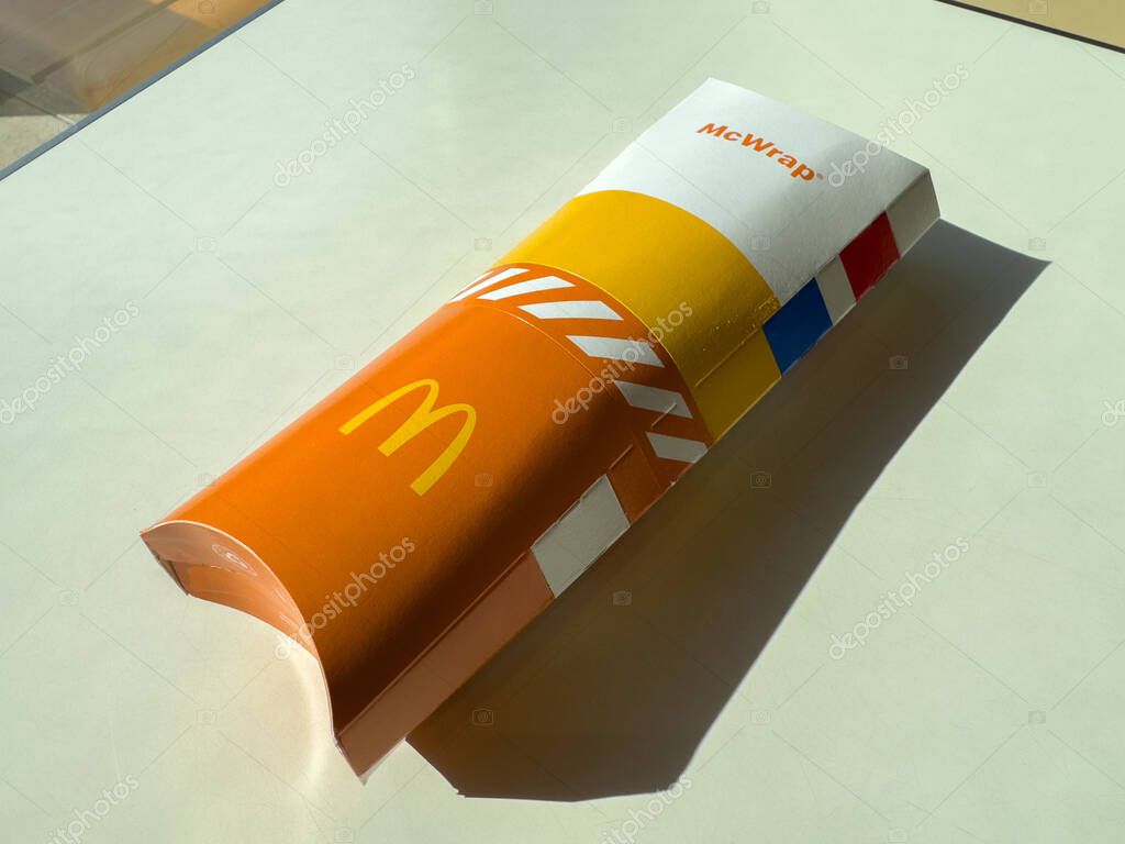 Villach, Austria - October 11, 2025: McDonald's McWrap packaging is presented on a smooth surface, highlighting its bright colors and recognizable logo for promotional use