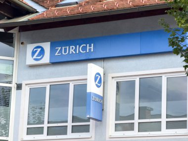 Althofen, Avusturya - 17 Eylül 2025: Zürih sigorta bürosunun belirgin logo ve tabelalarıyla dış görünüşü, çağdaş tasarım unsurlarını vurguluyor