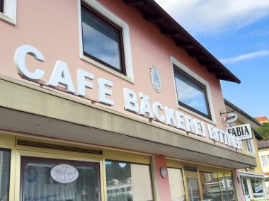 Althofen, Avusturya - 17 Eylül 2025: Cafe Backerei, kalın beyaz harflerle, sıcak ve davetkar bir fırın atmosferi oluşturan sevimli pembe bir dış görünüşe sahiptir.