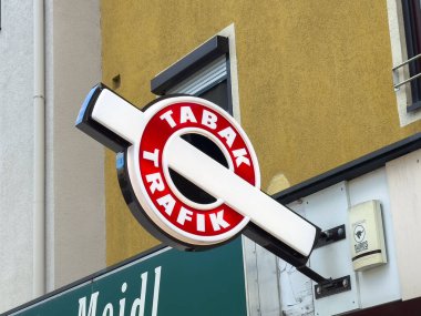 Althofen, Avusturya - 17 Eylül 2025: Mağaza vitrininde TABAK TRAFIK tabelası, canlı kırmızı ve beyaz renkler, kentsel yaşam tarzını ve yerel iş atmosferini vurguluyor