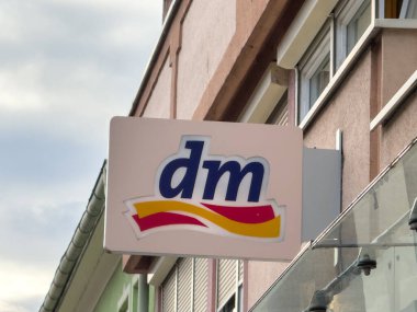Althofen, Avusturya - 17 Eylül 2025: dm mağaza tabelası dış inşaatlarda görülebilir olup, müşterileri çeşitli ürün ve hizmetleri keşfetmeye davet etmektedir