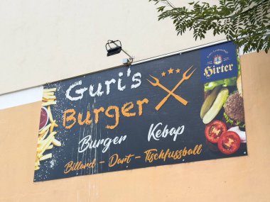 Althofen, Avusturya - 17 Eylül 2025: Guri 'nin Burger tabelası hamburger ve kebap gibi çeşitli gıda seçeneklerini göstererek, davetkar bir ortam yarattı