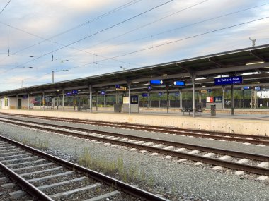 Althofen, Avusturya - 17 Eylül 2025: Boş tren istasyonu platformu modern tasarım ve açık bir tabela içeriyor, sakin bir şehir ortamı yaratıyor