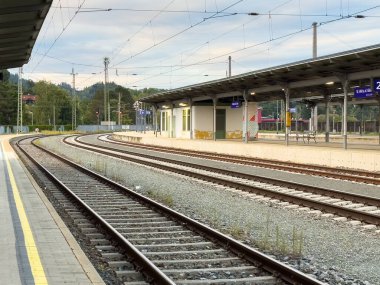 Althofen, Avusturya - 17 Eylül 2025: Tren istasyonu yemyeşil ile çevrili kıvrımlı raylar ve modern tasarım içeriyor, barışçıl bir seyahat ortamı yaratıyor