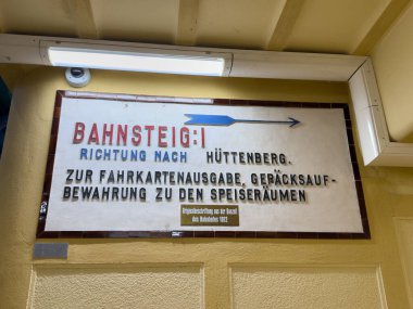Althofen, Avusturya - 17 Eylül 2025: Huttenberg tren istasyonunda tarihi tasarım ve seyahat bilgilerini gösteren vintage tabelası