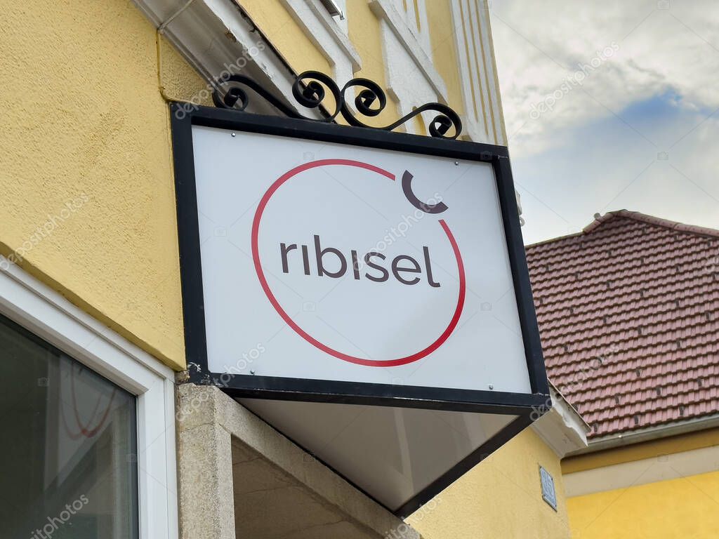 Althofen, Austria - September 17, 2025: Ribisel shop sign features modern design with vibrant colors, enhancing the urban atmosphere and inviting customers