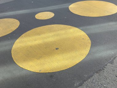 Soyut şehir sanatı: kaldırımda sarı dairesel desenler.