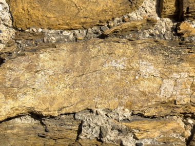 Yıpranmış tortul kaya katmanları ve çakıl taşlarına yakın çekim.