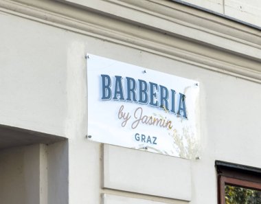 Graz, Avusturya - 11 Ekim 2025: Barberya by Jasmin Graz 'da bir binada, berber dükkanının şık markalaştırma ve hoş karşılama havasını vurguluyor.
