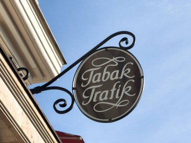 Graz, Avusturya - 11 Ekim 2025: Tabak Trafik tabelası arka planda açık mavi gökyüzü olan bir binada belirgin bir şekilde sergileniyor, davetkar bir şehir manzarası yaratıyor