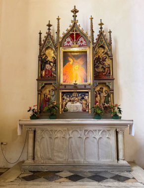 Graz, Avusturya - 11 Ekim 2025: Renkli dini sanat ve heykellerin yer aldığı sunak, tarihi bir kilisede sakin bir atmosfere sahip.