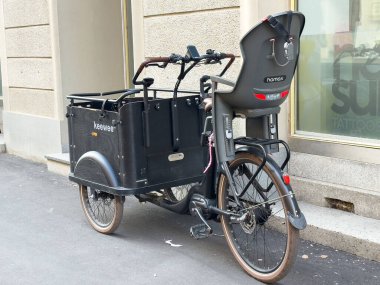 Graz, Avusturya - 11 Ekim 2025: Çocuk koltuklu siyah kargo bisikleti, aile içi taşınma ve şehir yaşamı için pratik tasarımı vurguluyor.