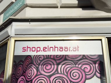 Graz, Avusturya - 11 Ekim 2025: Feuerbachgasse 'da yer alan canlı pembe spiral sanat eserlerinde mağaza önü.