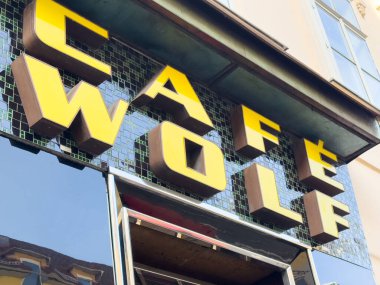 Graz, Avusturya - 11 Ekim 2025: Caffe Wolf, sarı harfli ve yansıtıcı camlı çarpıcı bir vitrin tabelasına sahiptir.