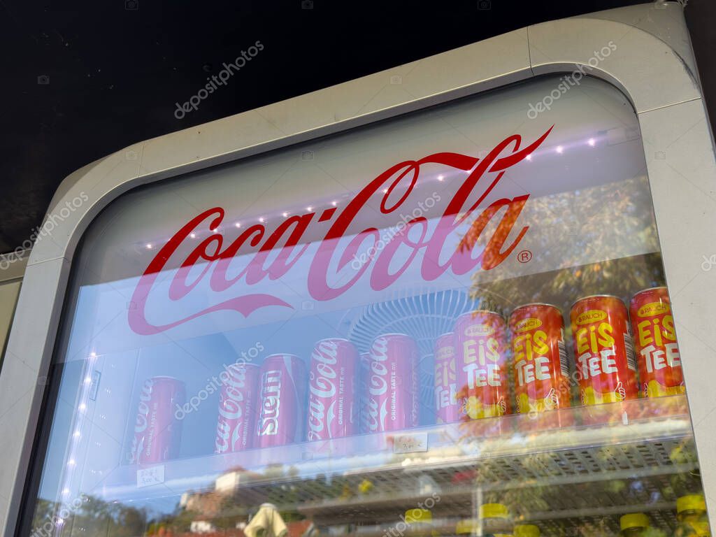 Graz, Austria - October 11, 2025: Coca-Cola vending machine showcases bright red cans and iced tea options in a lively outdoor environment